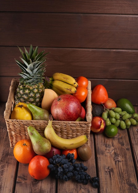 Mezcla de jugosas frutas tropicales exóticas coloridas frescas en la canasta sobre fondo de madera