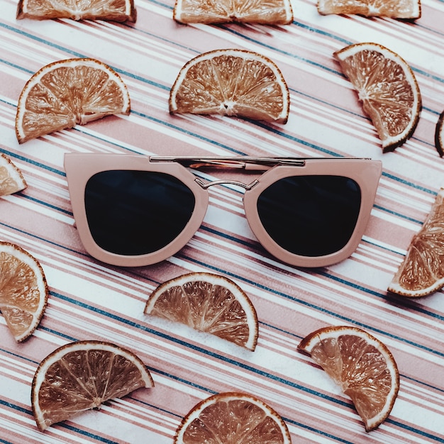 Foto mezcla de moda. naranjas y gafas de sol rosas con estilo.