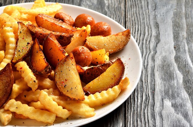 Mezcla de papas fritas, papas mexicanas y bolas de papa en un plato con espacio de copia