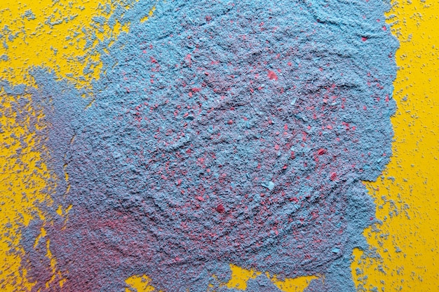 Mezcla de polvo azul y rojo sobre un fondo amarillo Espacio de copia Textura abstracta Vista superior