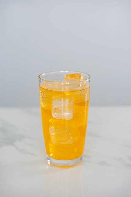 Mezcla de soda de zumo de naranja sobre fondo de azulejos de mármol