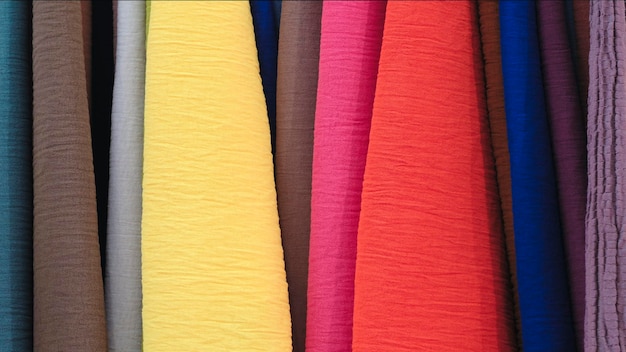 Foto mezcla telas textiles de rayas verticales colgantes coloridas en el estante textura de telas multicolores de cerca
