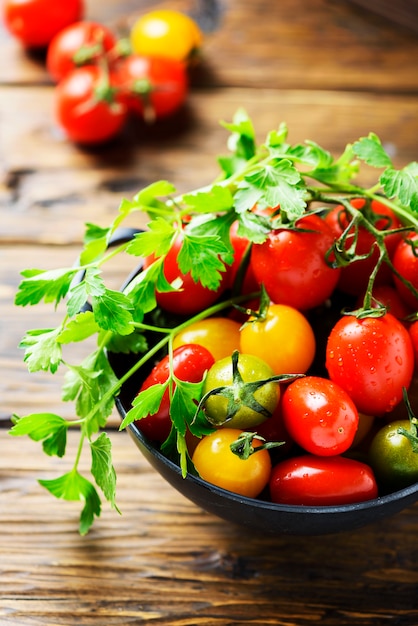 Mezcla de tomates rojos, amarillos y verdes con perejil.