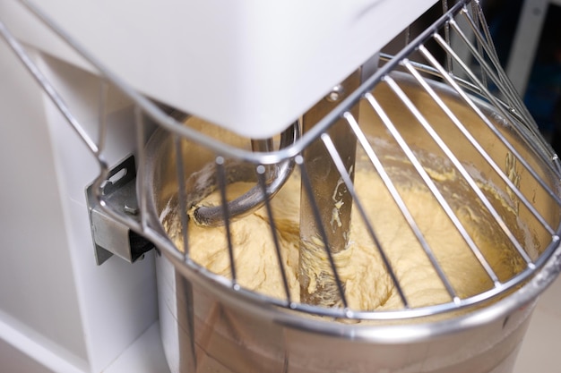 Un mezclador de pan en una panadería que amasa la masa para baguettes y rollos