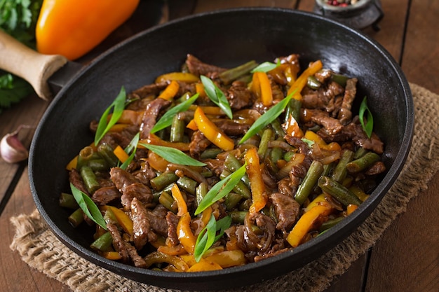 Mezclar carne frita con pimientos dulces y frijoles verdes