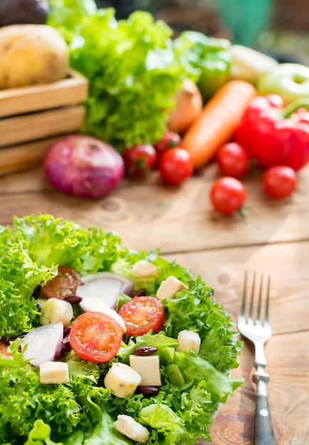 Mezclar ensalada y comida sana. Verduras orgánicas frescas para cocinar alimentos dietéticos sobre fondo de madera.