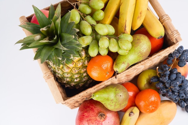 Mezclar variedad de jugosas frutas tropicales exóticas coloridas frescas en la canasta sobre fondo blanco vista superior