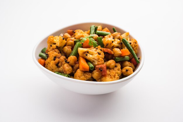 Mezcle la receta de vegetales secos en un tazón, receta de vegetales estilo restaurante indio servida con Chapati