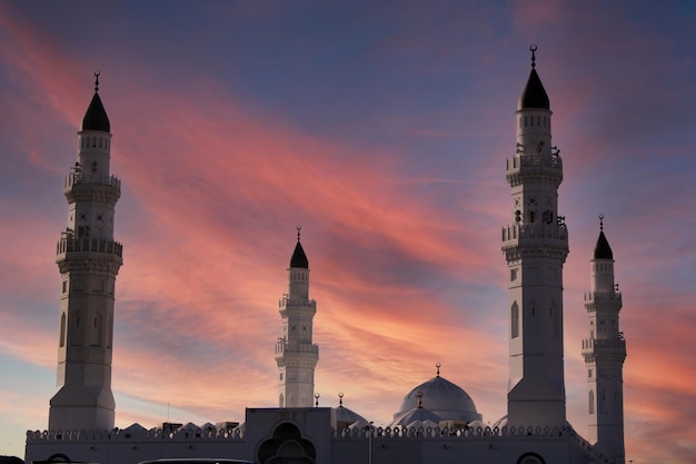 Una mezquita en medio de un atardecer con el cielo de fondo