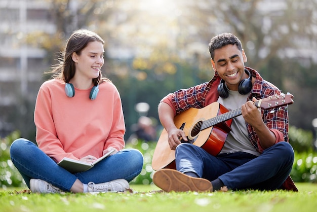 Este va para mi amor. Foto de un hombre y una mujer jóvenes tocando la guitarra en un descanso de estudio en la universidad.