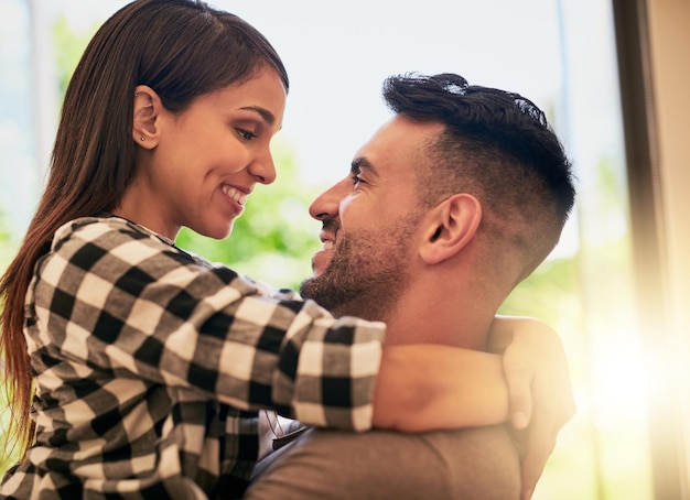 Foto mi corazón se derrite cuando te miro a los ojos foto de una joven pareja cariñosa uniéndose en casa