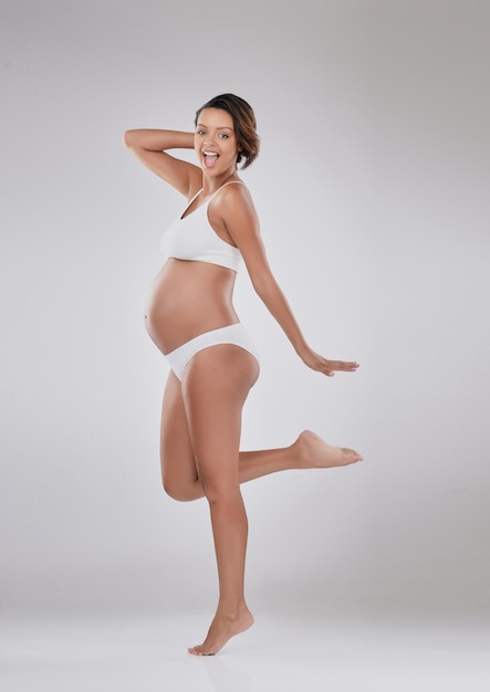 Mi cuerpo cambió y me encanta Retrato de estudio de una hermosa joven embarazada posando sobre un fondo gris