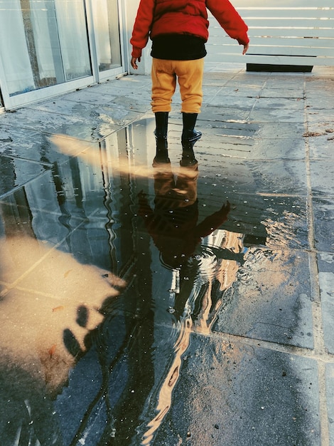 Foto mi hijo jugando en los charcos de lluvia después de un día de invierno lluvioso