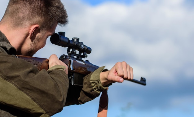 En mi objetivo. El cazador barbudo pasa la caza de ocio. Equipos de óptica de caza para profesionales. Pasatiempo masculino brutal. Hombre con el objetivo de fondo de naturaleza de destino. Habilidades de apuntar. Hunter mantenga el rifle apuntando.