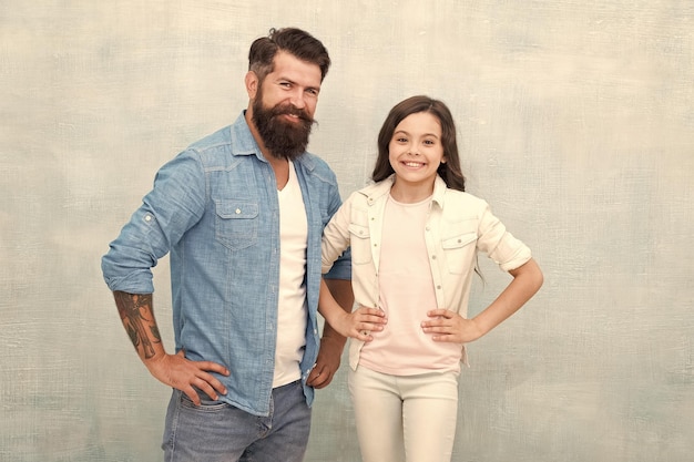 Mi padre es hipster Hipster feliz y niña sobre fondo gris Hipster barbudo y niño pequeño sonriendo en estilo casual Hipster caucásico y su adorable hija