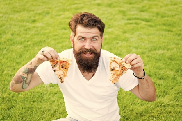 Mi pizza favorita picnic de verano en hierba verde fin de semana de pizza comida rápida hombre barbudo hipster comer pizza hombre feliz estudiante comiendo pizza divirtiéndose haciendo dieta esperará