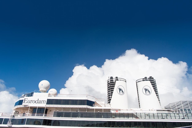 Miami, Estados Unidos - 31 de diciembre de 2015: cubiertas superiores y embudos gemelos de Eurodam. Fachada del crucero en el cielo azul nublado. Filas de ventanas y balcones de cabina. Transporte maritimo. Aventura y descubrimiento.