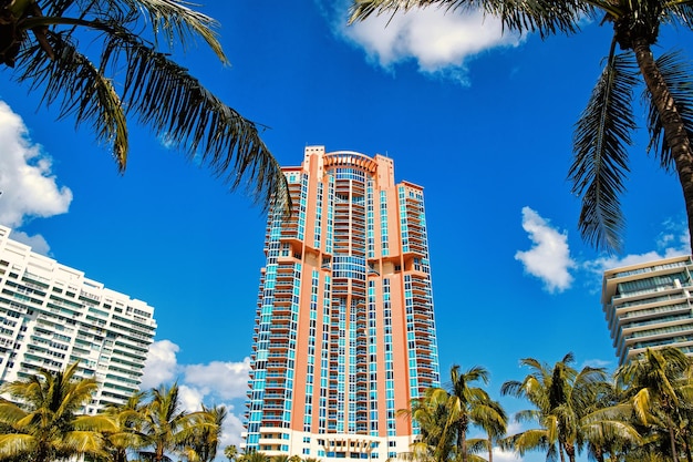 Miami, hohe Wohngebäude, Hotel oder Häuser im sonnigen Sommergrün des Südstrandes im Freien, Palmen und bewölkter blauer Himmel. moderne Architektur in Megalopolis. Business, Tourismus und Fernweh