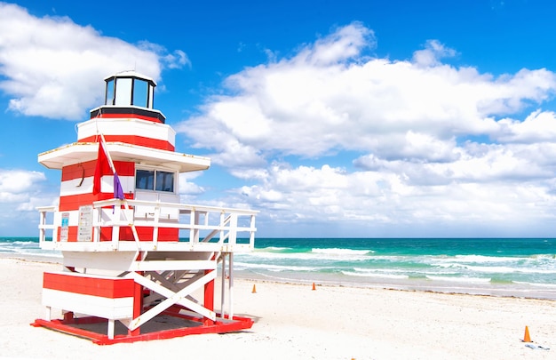 Miami, South Beach, Florida, Rettungsschwimmerhaus im typischen bunten Art-Deco-Stil an bewölktem Tag mit blauem Himmel und Atlantik im Hintergrund, weltberühmter Reiseort