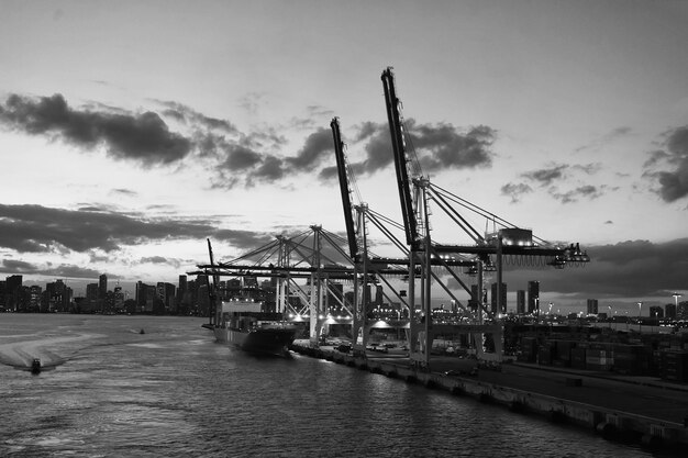 Miami USA 1. März 2016 Seehafen und Skyline der Stadt in der Abenddämmerung Seefracht Seeboote und Kräne mit Beleuchtung Seeschifffahrt Versand auf dem Wasser Seetransport und Transport