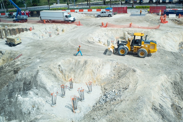 Miami, USA - 30. Oktober 2015: Arbeiter und Maschinen auf Baugrube. Baustelle arbeitet im sonnigen Außenbereich. Bau und Bautätigkeit. Entwicklungs- und Engineering-Konzept.