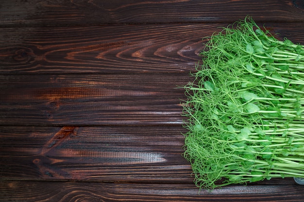 micro brotes de guisantes verdes picados en la mesa de madera vieja