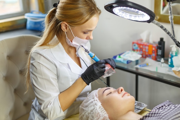 Microblading-Augenbrauen-Workflow in einem Schönheitssalon. Frau, die ihre Augenbrauen gefärbt hat. Semi-permanentes Make-up für die Augenbrauen. Konzentrieren Sie sich auf das Gesicht und die Augenbrauen des Models