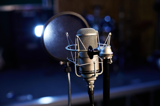 Foto microfone com um close-up de pop shield no fundo de um estúdio de gravação profissional microfone de suporte com um condensador para discos vocais alto-falantes e som de instrumento musical