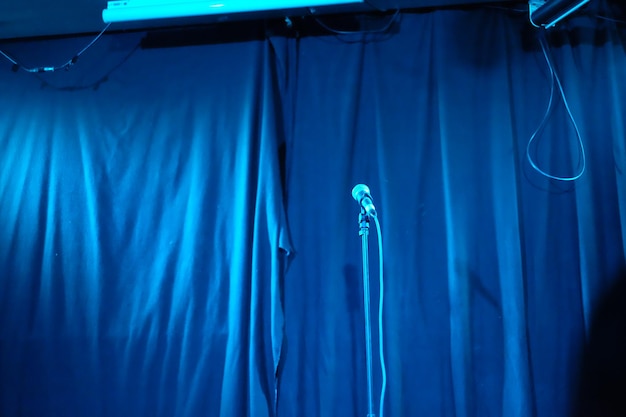 Foto microfone contra a cortina azul fechada no palco