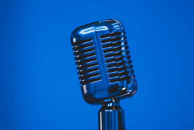 Microfone de prata vintage em fundo azul