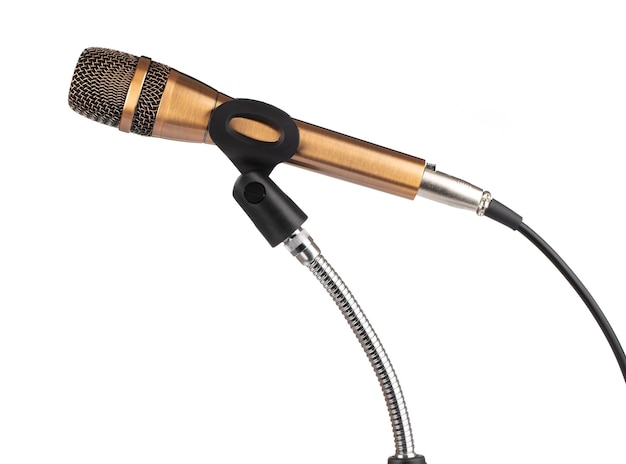 Microfone dourado no suporte isolado no fundo branco