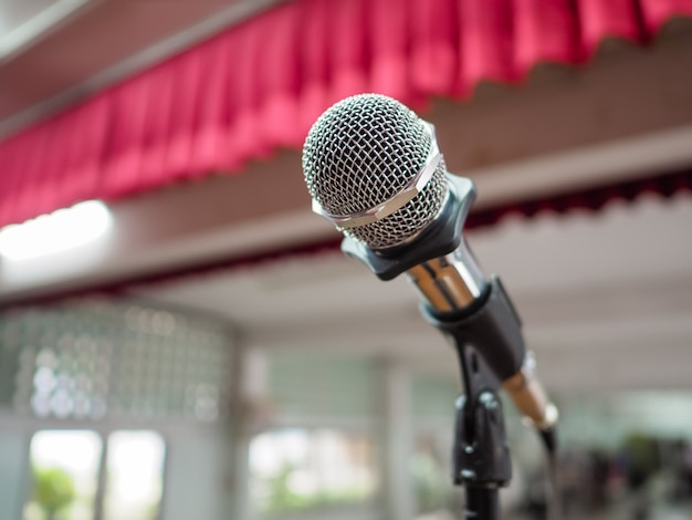 Microfone no palco contra um fundo de auditório.