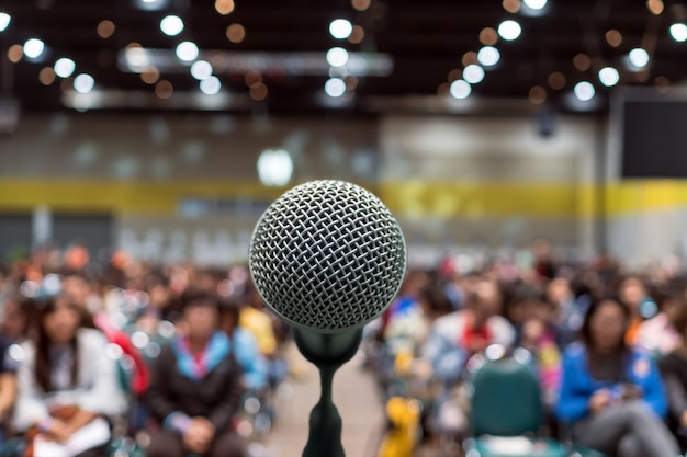 Microfone sobre a foto desfocada abstrata de sala de conferências ou sala de seminário no centro de exposições b