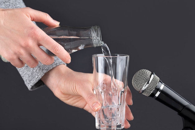 Micrófono asmr con agua vertida en un vaso para hacer sonido