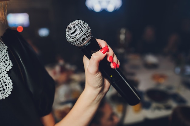 Micrófono y cantante femenina irreconocible de cerca