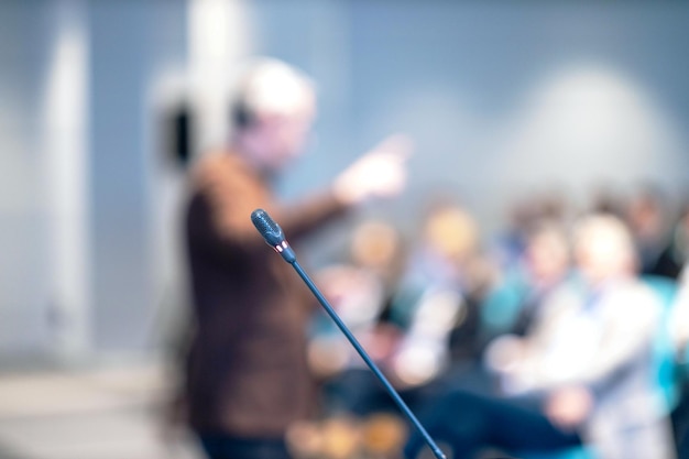 Foto el micrófono en foco borró al orador y a la audiencia en una conferencia o presentación de negocios de taller