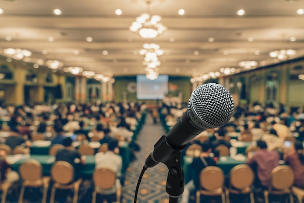 Micrófono con foto abstracta borrosa de la sala de conferencias o sala de reuniones con ba de asistentes