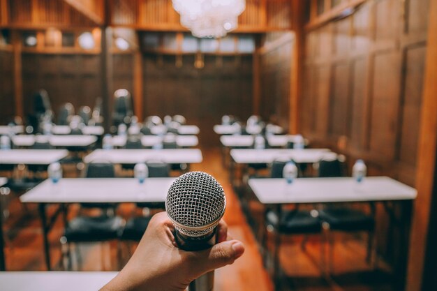 Micrófono de primer plano con gente borrosa que asiste al fondo del seminario. Proceso de vendimia.