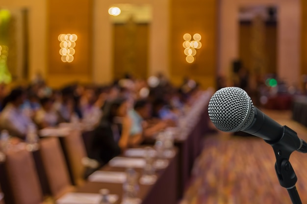 Micrófono sobre la foto borrosa abstracta de la sala de conferencias o seminario con backgrou asistentes