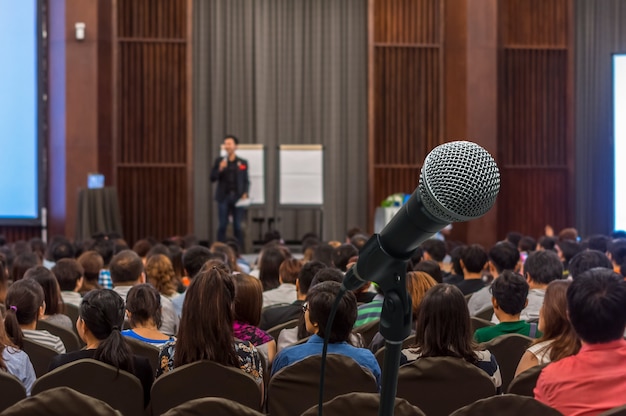 Micrófono sobre la foto borrosa abstracta de la sala de conferencias o seminario con backgrou asistentes