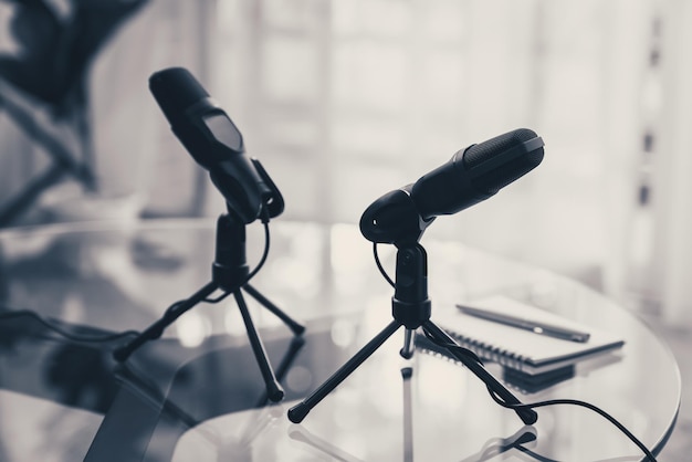 Foto el micrófono está sobre la mesa para el podcast en el estudio doméstico.