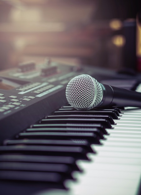 micrófono en el teclado de la música con fondo borroso de la marca de música