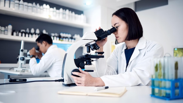 Microscópio de pesquisa e ciência com mulher em laboratório para medicina de vírus e farmácia Visão de objetivo e teste de vacina com cientista especialista e análise para biotecnologia de dados e saúde