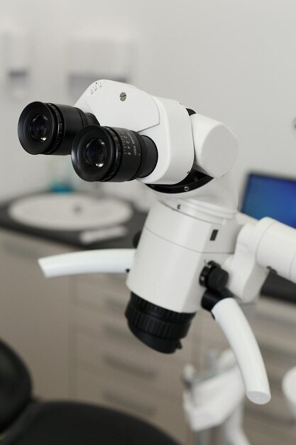 Microscopio dental en un consultorio dental fotografiado sobre un fondo blanco.