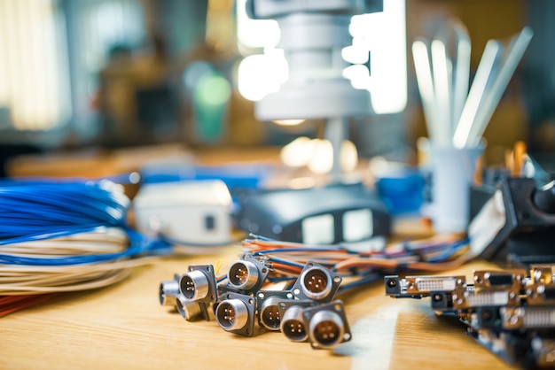 Foto microscópio eletrônico grande e moderno e microcircuitos embutidos são empilhados em uma placa de teste para se preparar para a pesquisa de componentes eletrônicos em um laboratório científico