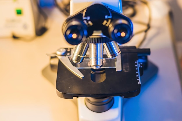 Microscópio óptico com quatro lentes objetivas diferentes