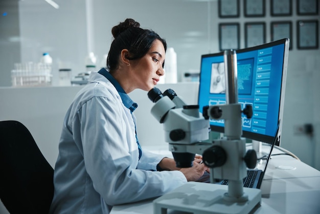 Microscopio de pantalla de computadora y ciencia con mujer en laboratorio para desarrollo, innovación o investigación Exhibición de datos y productos farmacéuticos con científico trabajando en avances o descubrimientos médicos