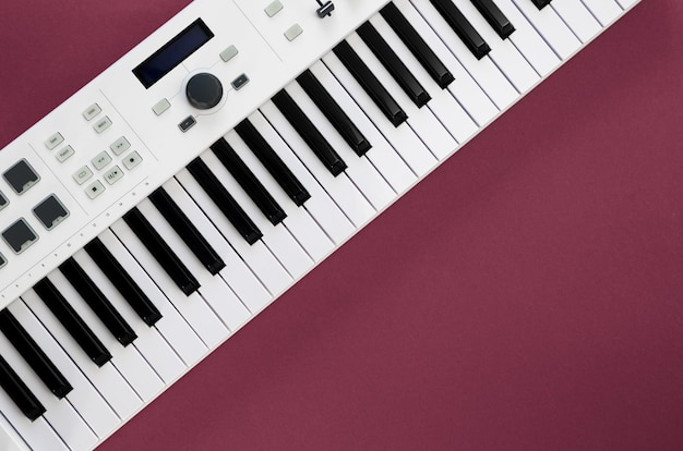 Midi-Tastatur auf magentafarbenem Hintergrund, flacher Kopierraum für musikalische Kreativität