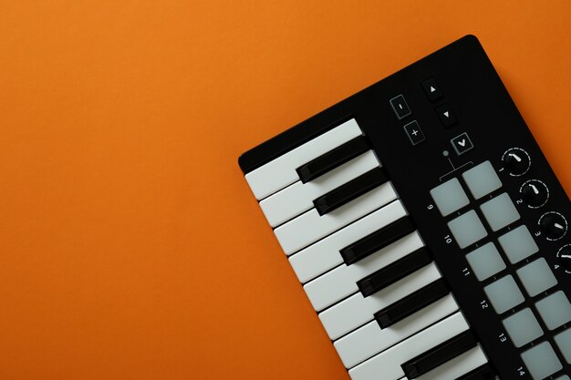 Midi-Tastatur auf orangem Hintergrund, Platz für Text