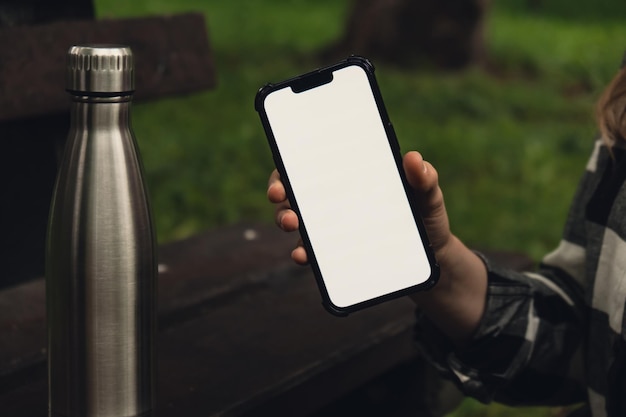 Foto mídia social do telefone móvel tela branca modelo para aplicativo móvel garrafa de água térmica de aço reutilizável